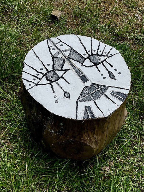 Painted face on a cut section of reclaimed wood